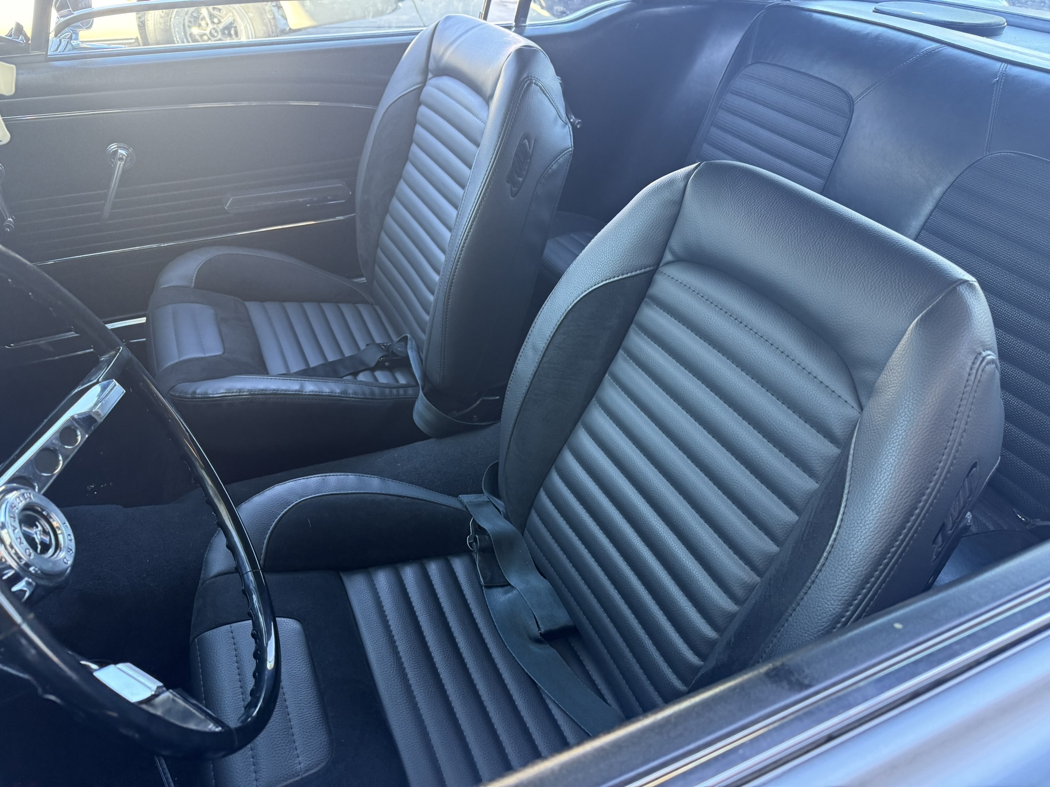 Dark upholstered front seats with horizontal stitching in a vehicle interior