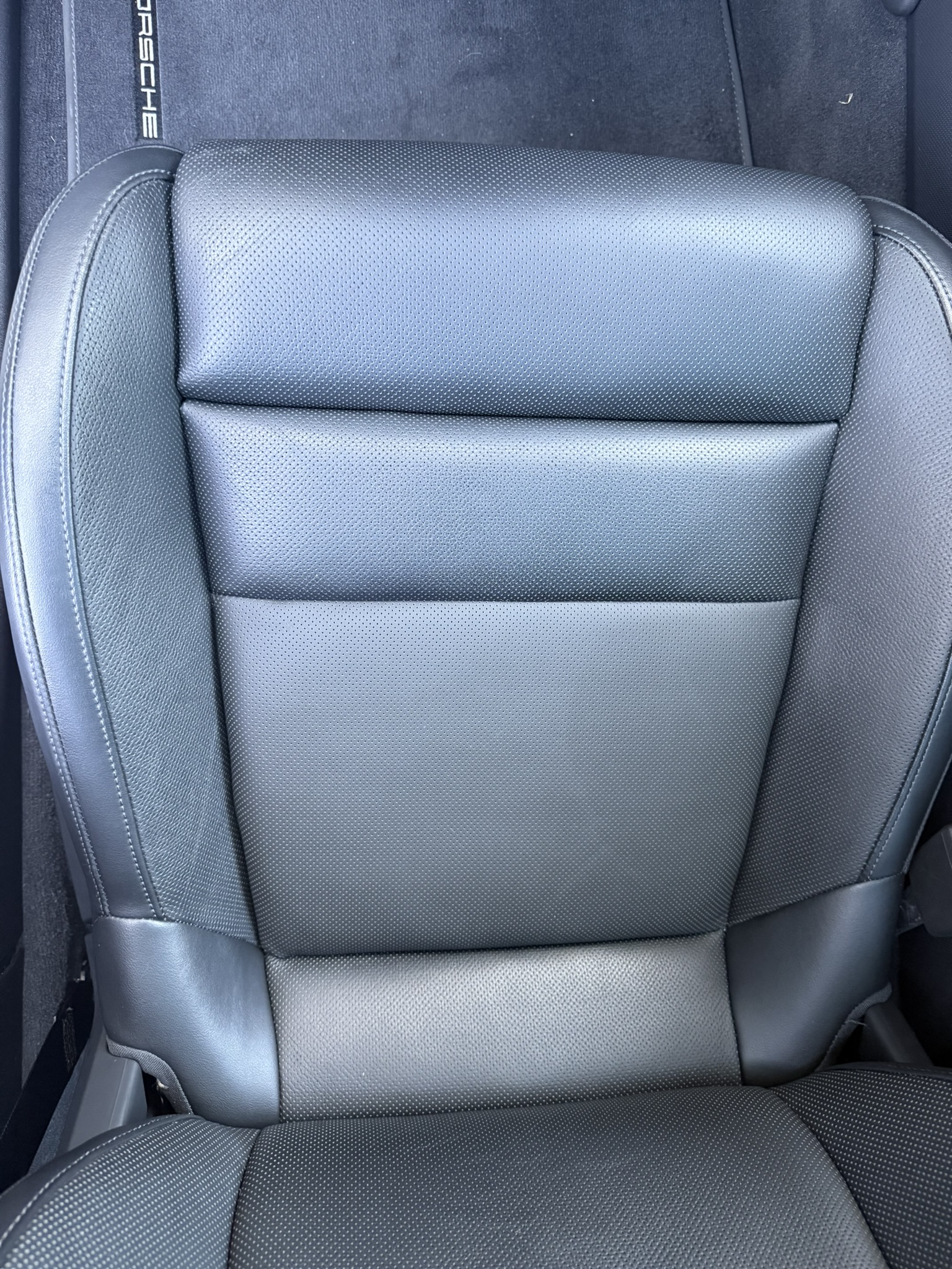 Gray upholstered vehicle seat with smooth panels and stitched bolsters